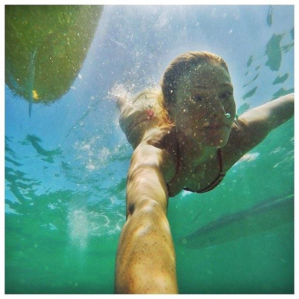 swimming under sup board
