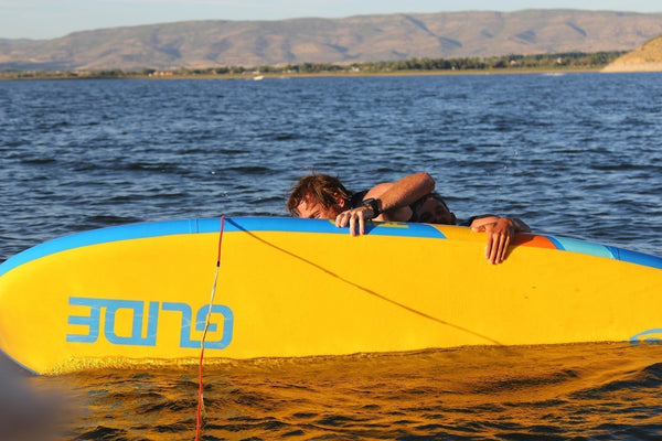 man trying to get back on a paddle board
